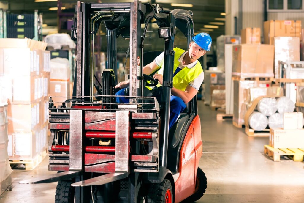 Heftruck verplaatst pallets in een magazijn tijdens de basisopleiding