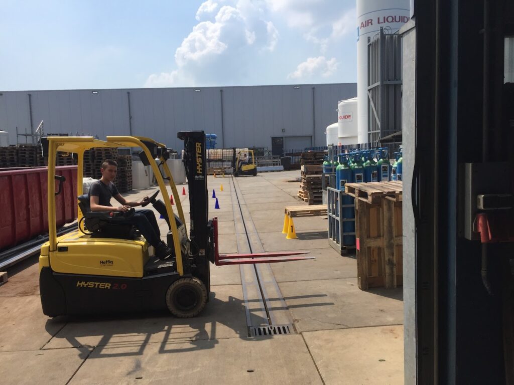 Chauffeur bedient een heftruck tijdens het praktijkgedeelte van de opleiding
